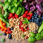 Un assortiment coloré de légumes à feuilles fraîches, de baies, de noix et de graines sur une table en bois rustique, mettant en valeur des aliment...
